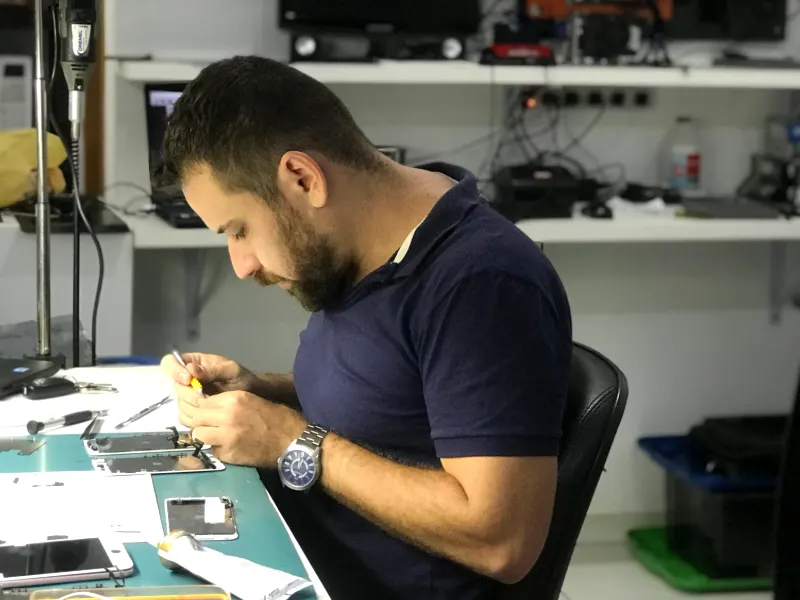 Técnico da InfoZenha concentrado em um reparo na bancada